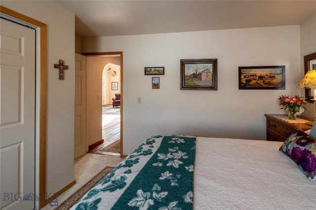 carpeted bedroom featuring arched walkways