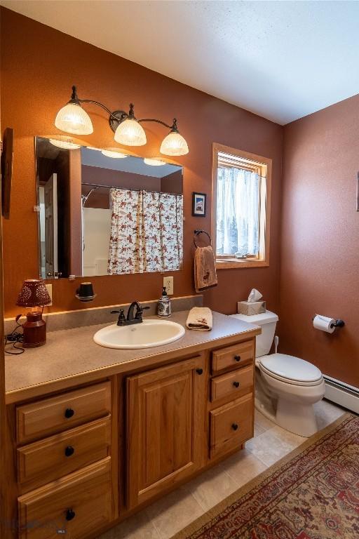 full bath with a shower with shower curtain, toilet, tile patterned floors, vanity, and a baseboard heating unit