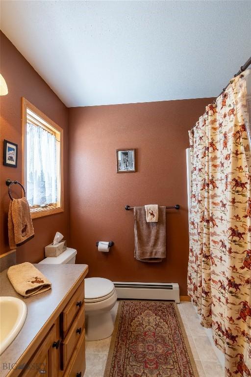 full bath with toilet, tile patterned floors, vanity, baseboard heating, and a shower with curtain