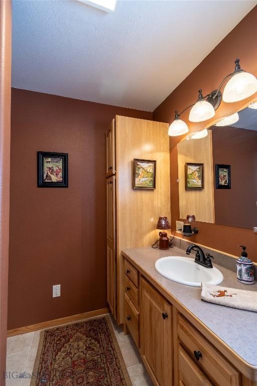 bathroom featuring vanity, baseboards, and tile patterned floors