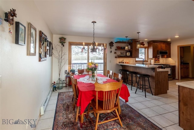 dining room with a chandelier, a baseboard radiator, recessed lighting, and light tile patterned floors