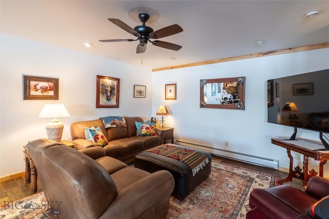 living room with a baseboard heating unit, ceiling fan, baseboards, and wood finished floors