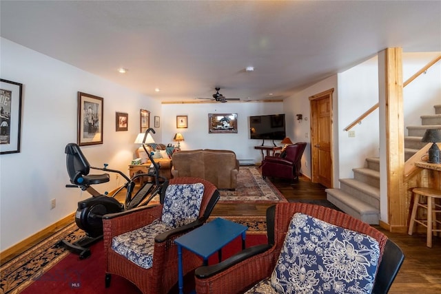 living area featuring stairs, baseboard heating, wood finished floors, and baseboards