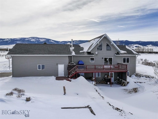 snow covered property with a wooden deck and stairs