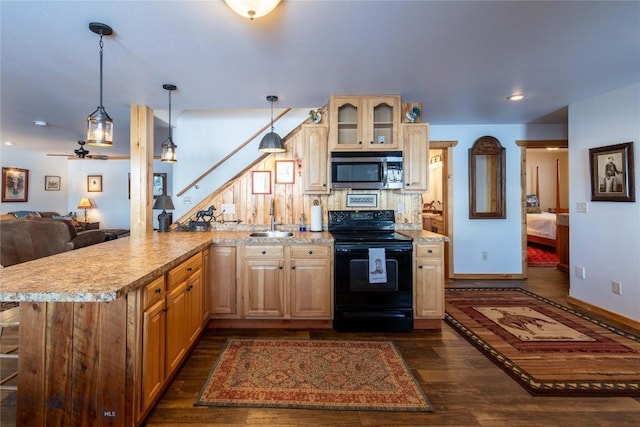 kitchen featuring dark wood-style floors, stainless steel microwave, black electric range oven, light countertops, and a sink