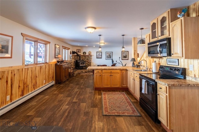 kitchen with stainless steel microwave, a peninsula, a wood stove, black / electric stove, and baseboard heating