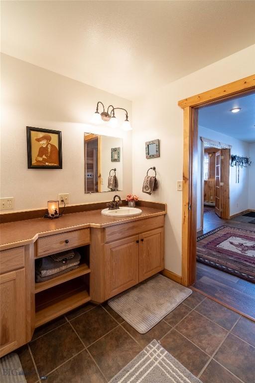 bathroom with vanity, baseboards, and tile patterned floors