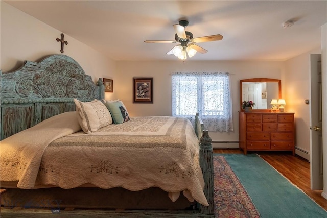 bedroom with a ceiling fan, baseboards, baseboard heating, and wood finished floors