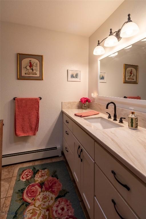 bathroom with a baseboard heating unit, tile patterned flooring, and vanity