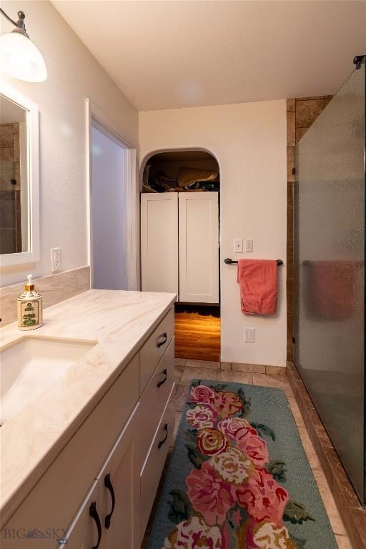 bathroom with a shower stall, tile patterned flooring, and vanity