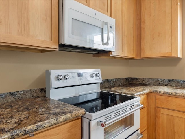 kitchen with white appliances and light brown cabinetry