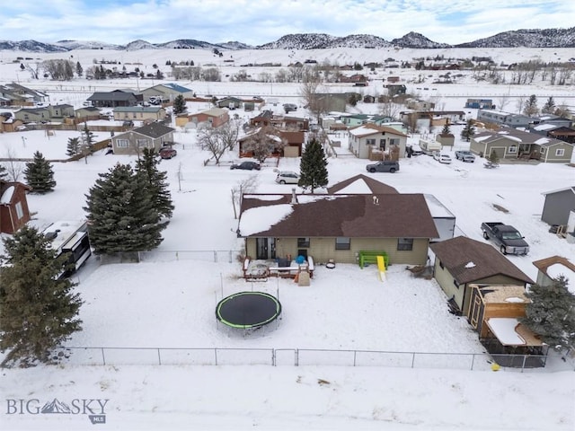 snowy aerial view featuring a residential view and a mountain view