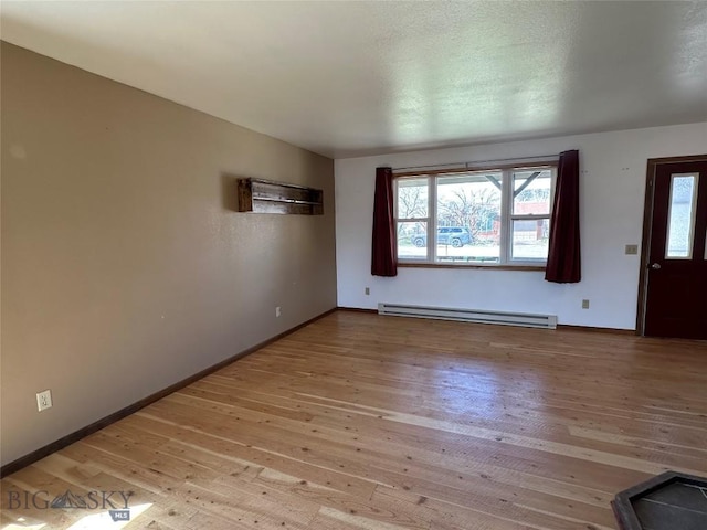 unfurnished living room featuring hardwood / wood-style flooring, plenty of natural light, baseboards, and baseboard heating
