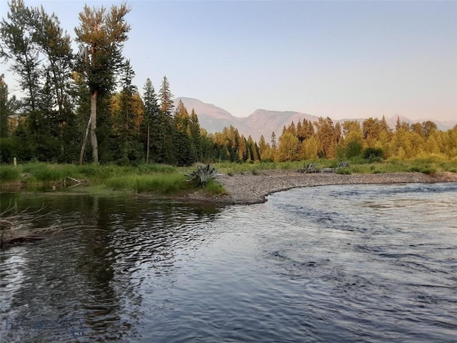 view of water feature featuring a mountain view and a wooded view