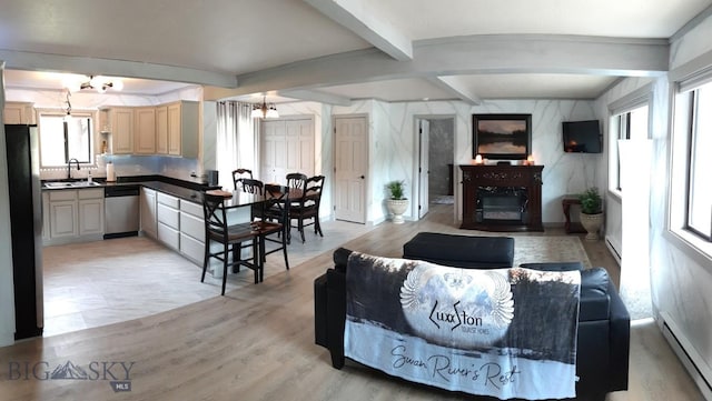 living room with arched walkways, beam ceiling, baseboard heating, light wood-style floors, and a glass covered fireplace