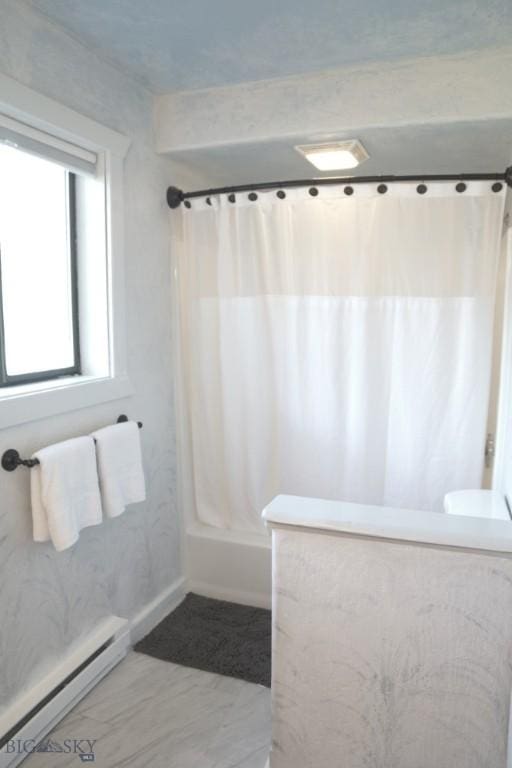 bathroom featuring a baseboard heating unit and shower / tub combo with curtain