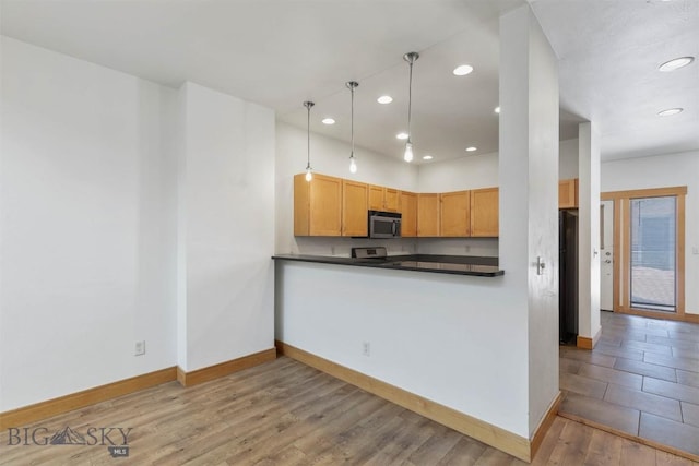 1281 Stoneridge Unit A, Bozeman, MT 59718 - kitchen with stainless steel appliances, recessed lighting, dark countertops, wood finished floors, and pendant lighting