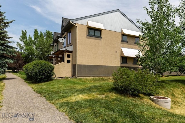 1281 Stoneridge Unit A, Bozeman, MT 59718 - view of home's exterior featuring a yard and stucco siding