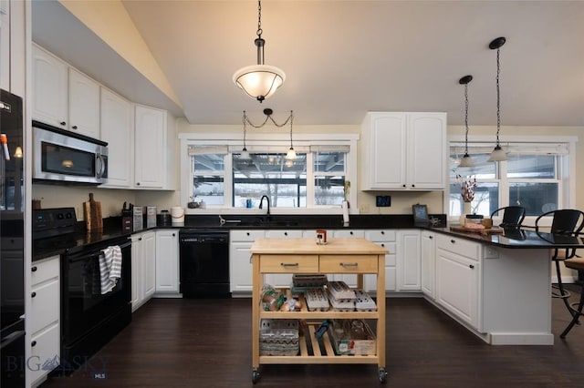 kitchen featuring white cabinetry, vaulted ceiling, a sink, a peninsula, and black appliances