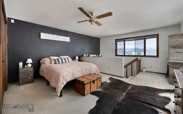 bedroom with ceiling fan, baseboards, a textured ceiling, and light colored carpet