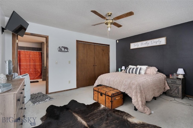 bedroom featuring a closet, light colored carpet, ceiling fan, a textured ceiling, and baseboards