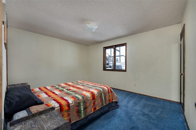 carpeted bedroom featuring baseboards and a textured ceiling