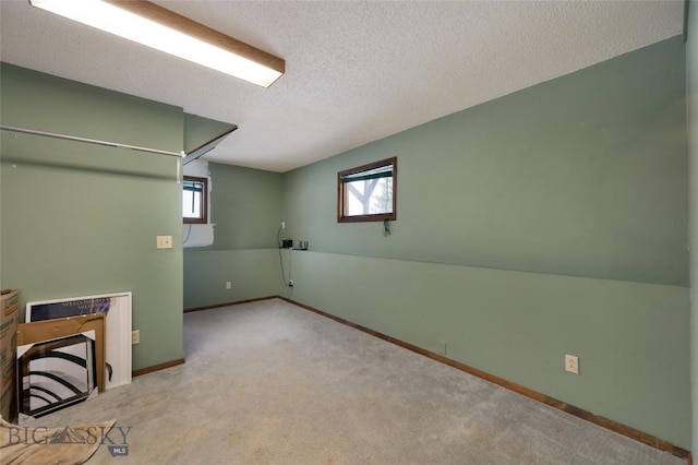 below grade area with carpet, a healthy amount of sunlight, and baseboards