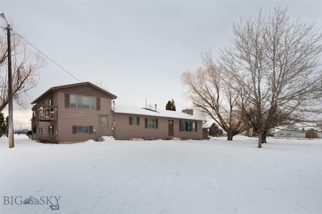 view of snow covered rear of property