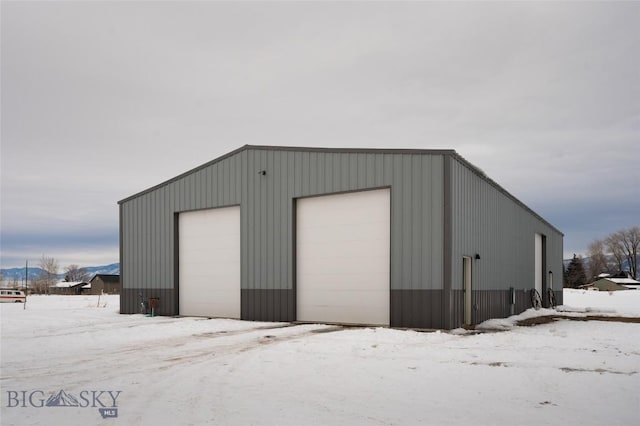 snow covered garage featuring a garage