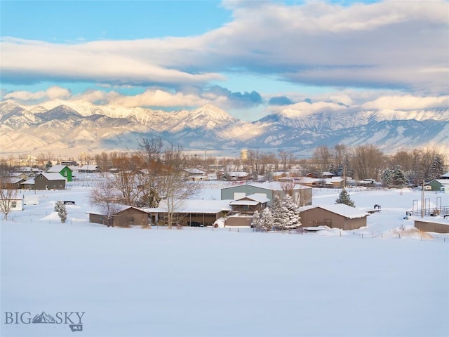 snowy aerial view with a residential view and a mountain view