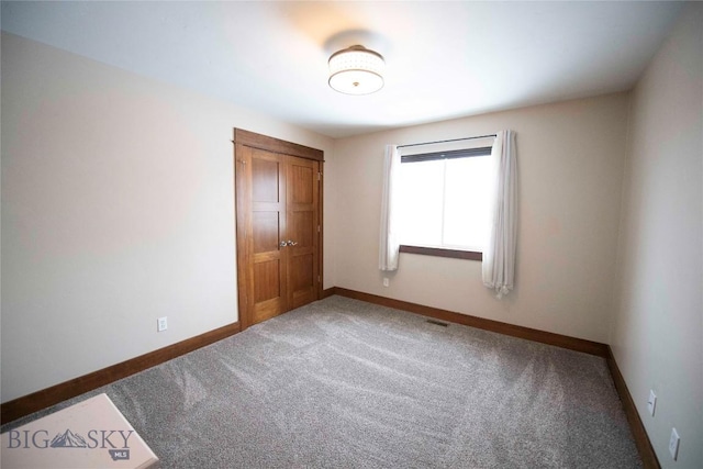 unfurnished bedroom featuring a closet, carpet flooring, visible vents, and baseboards