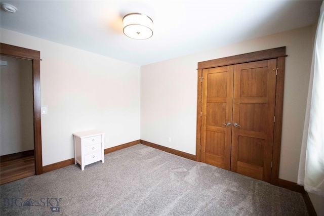 unfurnished bedroom featuring a closet, carpet flooring, and baseboards