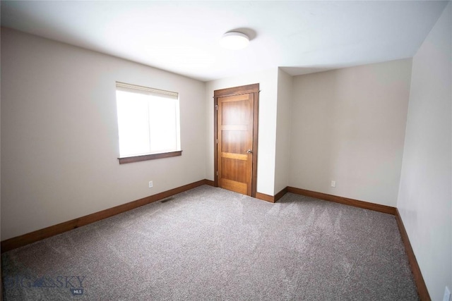 unfurnished room featuring carpet floors and baseboards