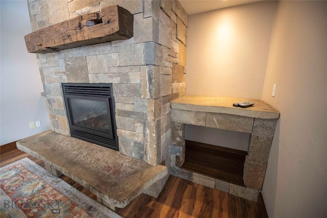 room details with wood finished floors and a stone fireplace