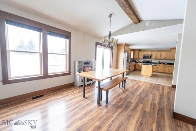 dining space featuring visible vents, lofted ceiling with beams, an inviting chandelier, light wood-style floors, and baseboards