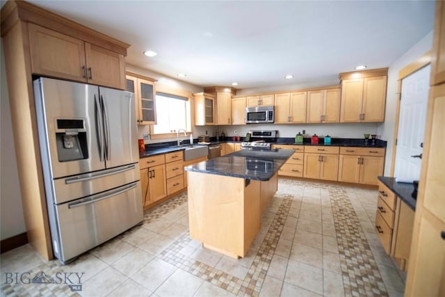 kitchen with a kitchen island, glass insert cabinets, stainless steel appliances, light brown cabinets, and recessed lighting