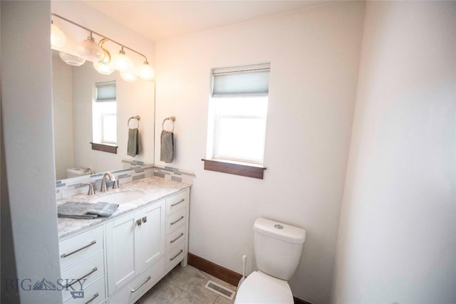 bathroom featuring baseboards, visible vents, vanity, and toilet