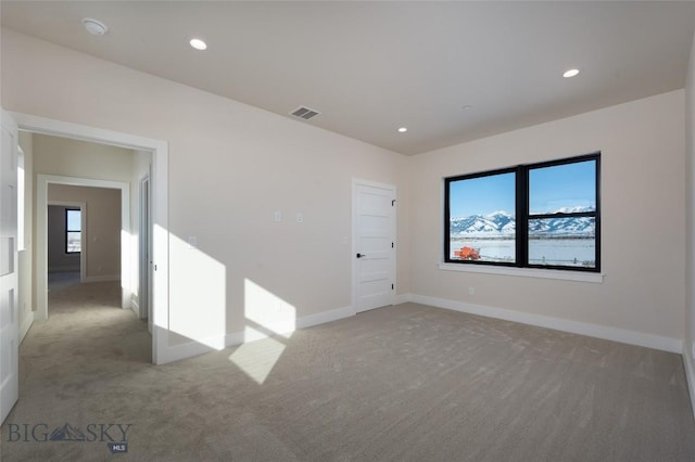 carpeted empty room with recessed lighting, visible vents, and baseboards