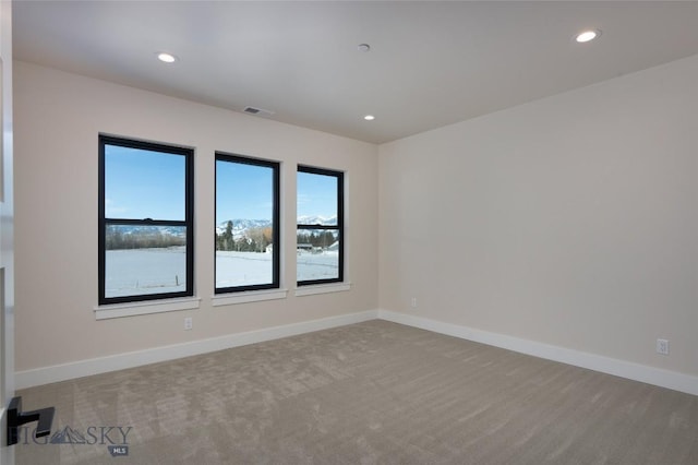 empty room with carpet floors, recessed lighting, visible vents, and baseboards