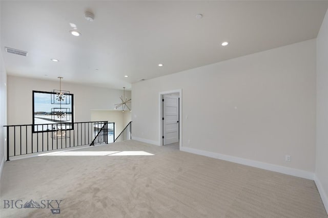 empty room featuring light carpet, recessed lighting, a notable chandelier, and baseboards