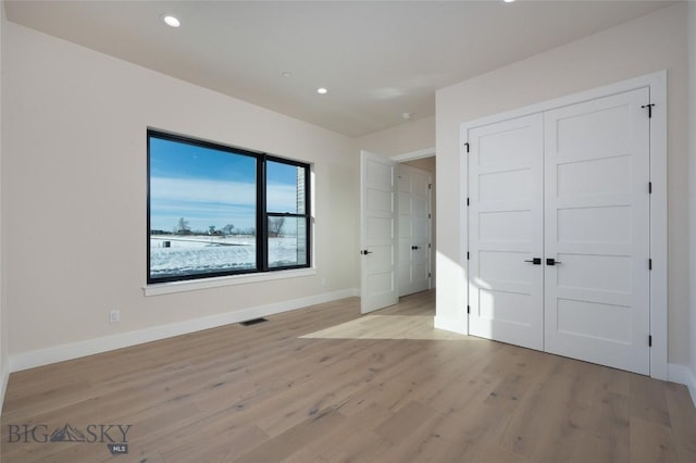 unfurnished bedroom with recessed lighting, visible vents, baseboards, a closet, and light wood finished floors