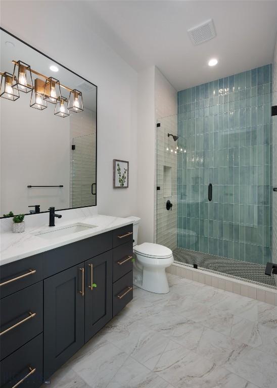 bathroom with visible vents, toilet, marble finish floor, vanity, and a shower stall