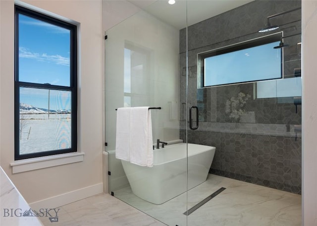 bathroom featuring marble finish floor, a soaking tub, a shower stall, and baseboards