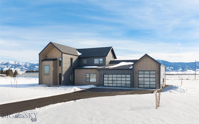 view of front of property featuring a garage, driveway, board and batten siding, and a mountain view