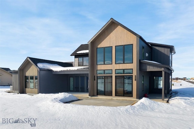 snow covered property with a patio