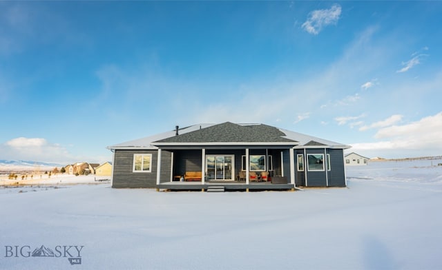 view of snow covered rear of property