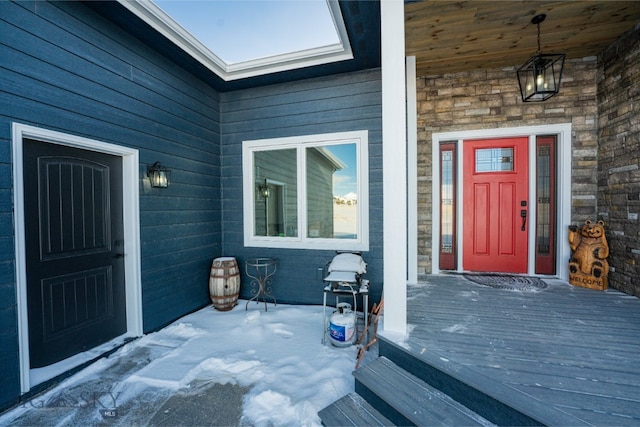 entrance to property featuring a porch and stone siding