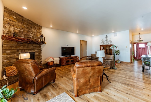 living area with recessed lighting, a fireplace, and wood finished floors