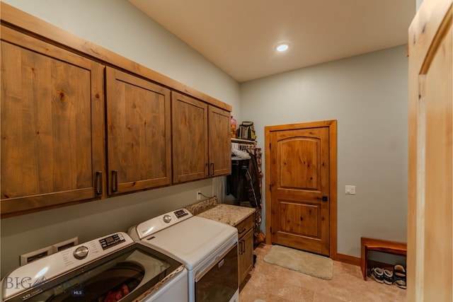 washroom featuring cabinet space, baseboards, and separate washer and dryer