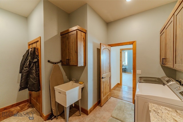 washroom with washer and clothes dryer, cabinet space, and baseboards